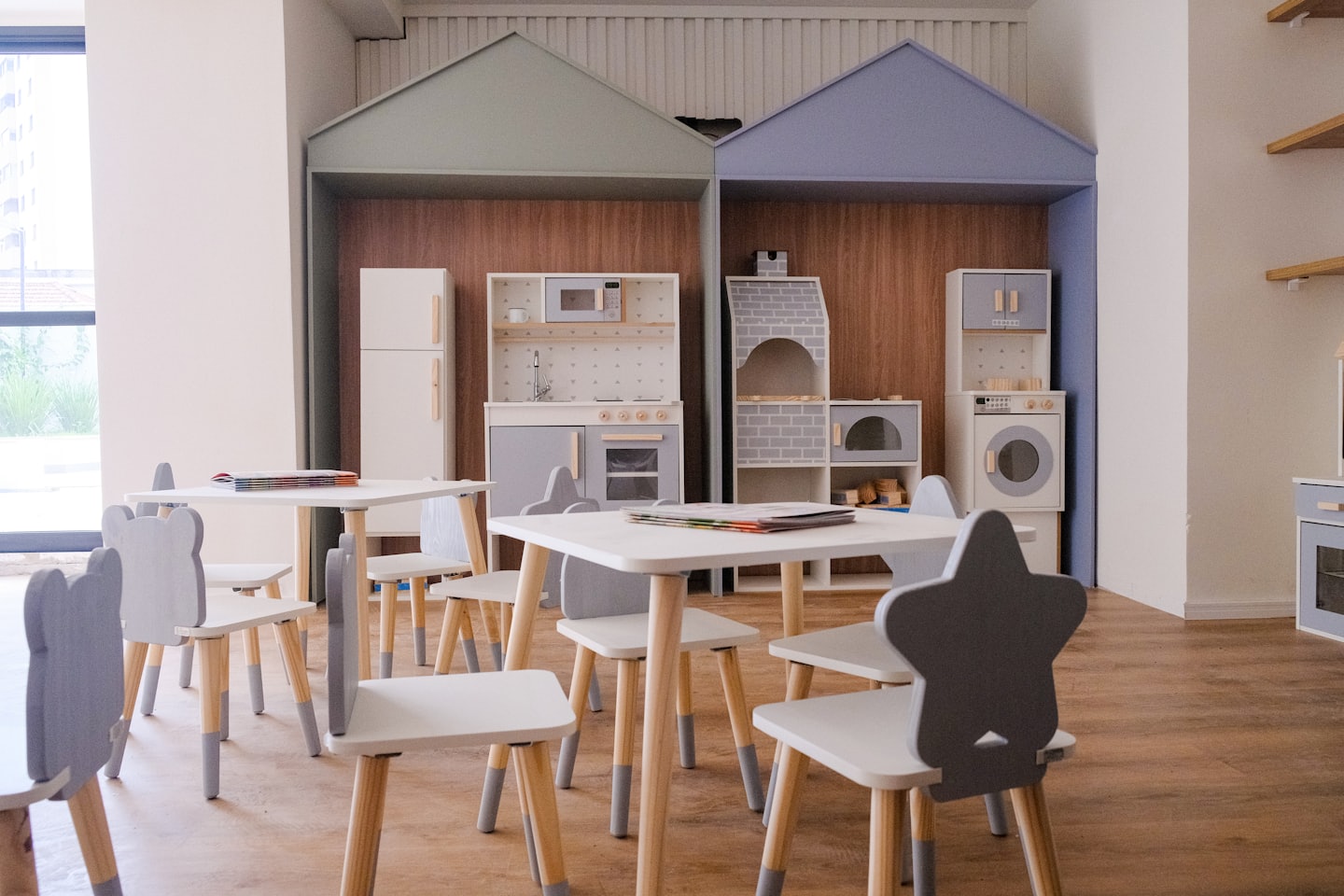 Children's playroom with bear and star chairs at small tables.