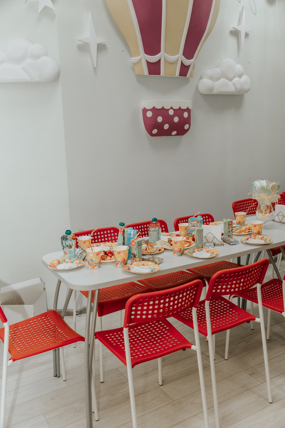 Table set for a party with colorful plates and decorations.