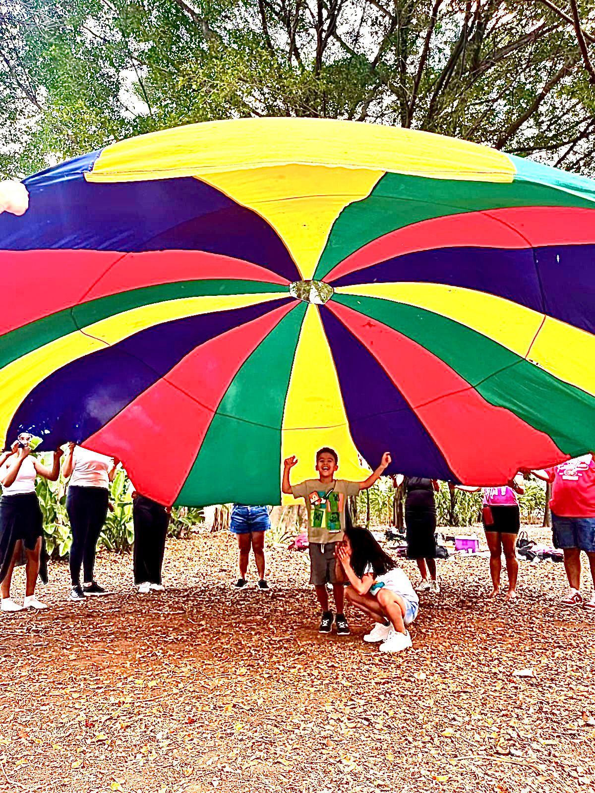 Brincadeira com paraquedas colorido em festa infantil